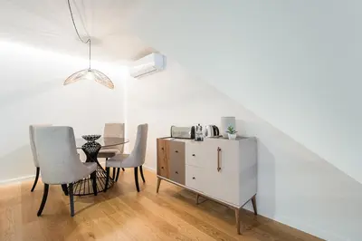 a dining room with a table and chairs and a cabinet at GuestReady - Vera Cruz Apartments in Porto