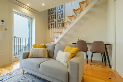 a living room with a couch and a staircase at Luxury Style 4 with AC Downtown Porto near Metro in Porto