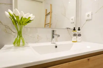 a bathroom sink with a vase of flowers on it at Luxury Style 4 with AC Downtown Porto near Metro in Porto