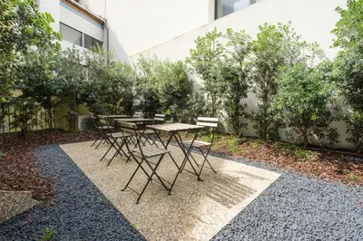 a table and chairs in a courtyard with trees at Luxury Style 4 with AC Downtown Porto near Metro in Porto