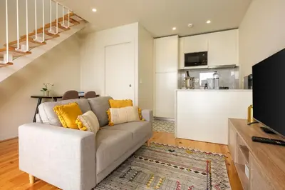 a living room with a couch and a kitchen at Luxury Style 4 with AC Downtown Porto near Metro in Porto