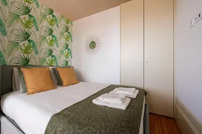 a small bedroom with a bed with a green blanket at Cedofeita Sunshine Luxury Apartment Downtown Porto in Porto