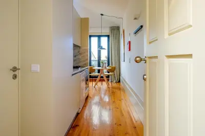 a kitchen with white walls and a wooden floor at Cedofeita Sunshine Luxury Apartment Downtown Porto in Porto