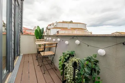 a balcony with a table and chairs on a roof at Cedofeita Sunshine Luxury Apartment Downtown Porto in Porto