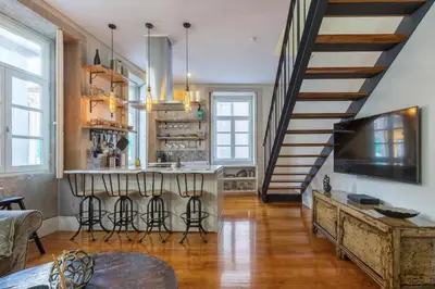 a kitchen with a bar with stools at Stylish Downtown Porto Duplex 2BR Walk everywhere! in Porto