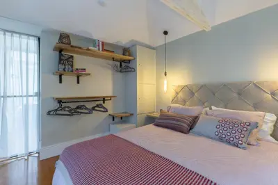 a bedroom with a large bed with a purple blanket at Stylish Downtown Porto Duplex 2BR Walk everywhere! in Porto