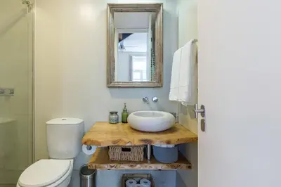 a bathroom with a sink and a toilet and a mirror at Stylish Downtown Porto Duplex 2BR Walk everywhere! in Porto