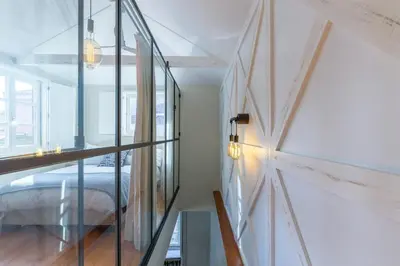 a room with a bed and a glass wall at Stylish Downtown Porto Duplex 2BR Walk everywhere! in Porto