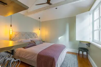 a bedroom with a bed and a table and window at Stylish Downtown Porto Duplex 2BR Walk everywhere! in Porto