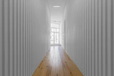 a hallway with white walls and a wooden floor at Stylish Downtown Porto Duplex 2BR Walk everywhere! in Porto