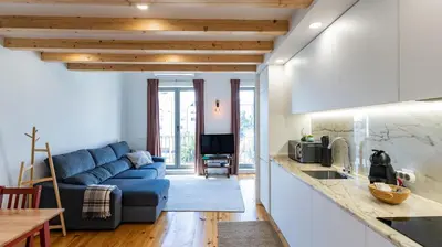 a living room with a blue couch in a kitchen at Stylish Duplex with Balcony in Porto by LovelyStay in Porto