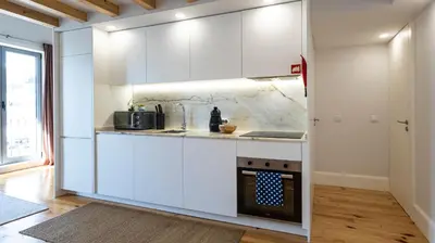 a kitchen with white cabinets and an oven at Stylish Duplex with Balcony in Porto by LovelyStay in Porto