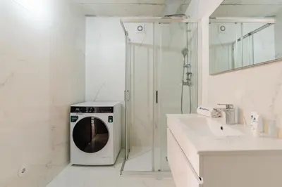 a washing machine in a bathroom next to a sink at HostWise - Modern Flat w/ Balcony, Garage & Pool in Vila Nova de Gaia
