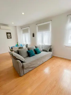 a couch in a living room with a wooden floor at Bonfim - Porto River in Porto