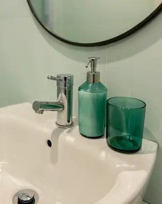 a sink with a soap dispenser and a glass on it at Bonfim - Porto River in Porto