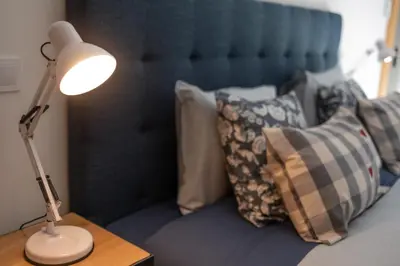 a lamp on a table next to a bed with pillows at Porto Cathedral III in Porto