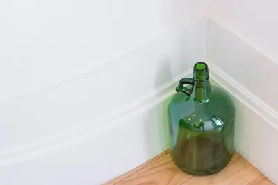 a green glass bottle sitting on the floor at GuestReady - Rose Apartment in Porto