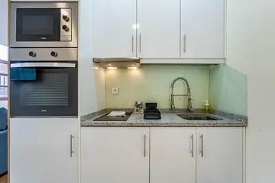 a kitchen with white cabinets and a sink at Close to Everything Your Oporto Blue PRM 2F in Porto