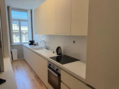 a kitchen with white counters and a sink and a window at Apartment in Market Bolhão- W Views 2F in Porto