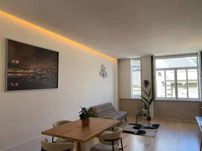 a living room with a wooden table and chairs at Apartment in Market Bolhão- W Views 2F in Porto