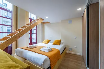 a room with a bed with white sheets and pillows at Close to Everything Your Oporto Yellow PRM 1F in Porto