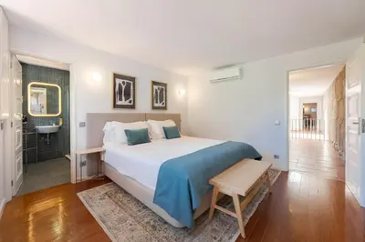 a bedroom with a large bed and a bathroom at Feel Porto Ribeira Vintage Duplex in Porto