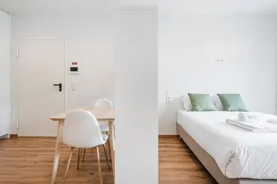 a bedroom with a bed and a table and a chair at GuestReady – The Mythic Apartments in Porto