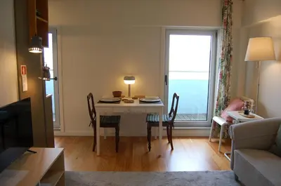 a living room with a table with chairs and a window at Penthouse Inn Bolhão in Porto