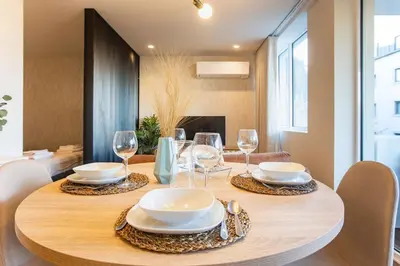 a wooden table with plates and wine glasses on it at Porto Gallery District Escape, Central Retreat in Porto