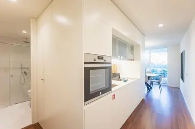 a kitchen with white cabinets and a television on a counter at Porto Gallery District Escape, Central Retreat in Porto