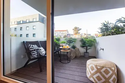 a balcony with a chair and a table on a balcony at Porto Gallery District Escape, Central Retreat in Porto