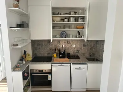 a kitchen with white cabinets and a counter top at Casa da Praceta in Porto