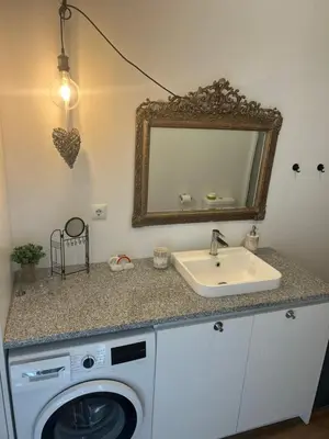 a shelf with glasses and bottles on a white wall at Casa da Praceta in Porto