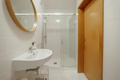 a white bathroom with a sink and a shower at Stylish Flat by Hosty in Porto