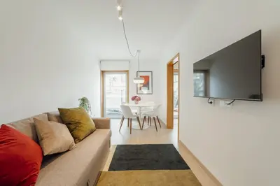 a living room with a couch and a television on a wall at Stylish Flat by Hosty in Porto