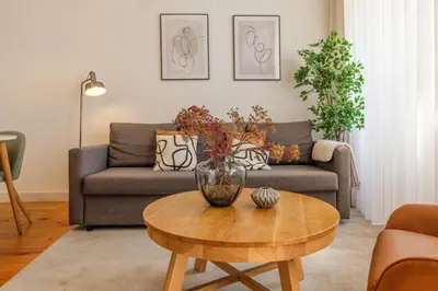 a living room with a couch and a table with a vase on it at Historic Porto Nook Downtown Porto near metro in Porto
