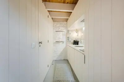 a bathroom with white walls and a hallway with a sink at GuestReady - A special place in Porto in Porto