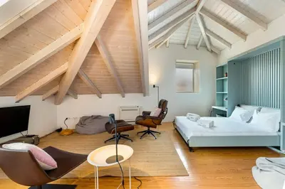 a bedroom with a bed and chairs in a room at GuestReady - A Porto Nest with a Twist in Porto