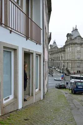 a woman looking out of a window of a building at Spot Apartments Sao Bento in Porto