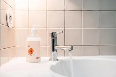 a bottle of soap sitting on a sink next to a faucet at GuestReady - Unfolded in Porto
