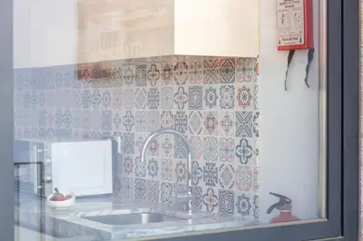 a kitchen with a sink and a tile wall at Santa Teresa Studio by LovelyStay in Porto
