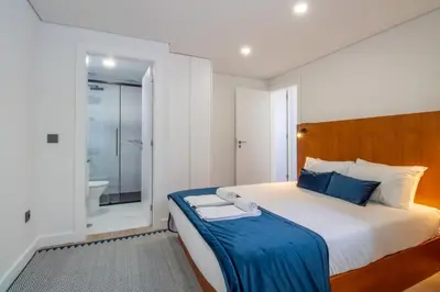 a bedroom with a large bed and a bathroom at Quiet Duplex w Patio in Lapa by LovelyStay in Porto