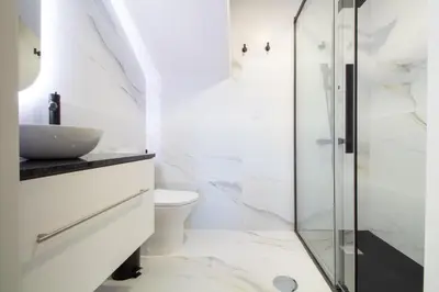 a bathroom with a glass shower and a toilet at Quiet Duplex w Patio in Lapa by LovelyStay in Porto