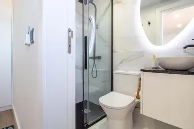a bathroom with a shower and a toilet and a sink at Quiet Duplex w Patio in Lapa by LovelyStay in Porto