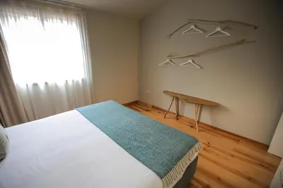 a bedroom with a bed and a window and hangers at My Ribeira Guest House in Porto