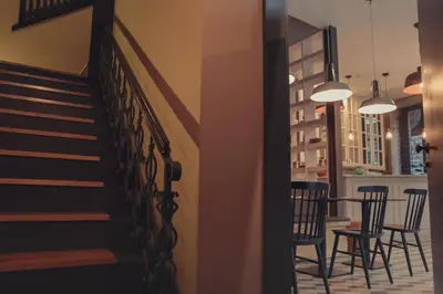 a hallway with a staircase and chairs and a table at My Ribeira Guest House in Porto