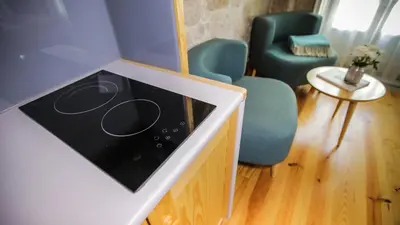 a room with a counter with a tv and chairs at My Ribeira Guest House in Porto