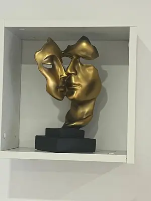 a bronze statue of two people kissing on a shelf at White Stripes House of Music in Porto
