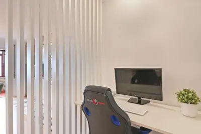 a desk with a computer monitor and a chair at White Stripes House of Music in Porto