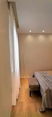 a bedroom with a bed and a window with curtains at Apartamento D'Alegria in Porto
